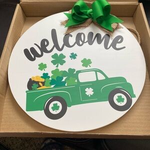 Welcome sign for St. Patrick’s Day. Green Shamrocks and pot of gold with Bow.
